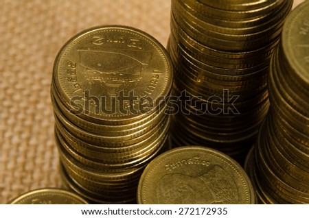 Stack of Thai gold coin on brown sack background