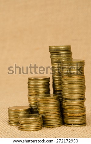 Stack of gold coins on brown sack background