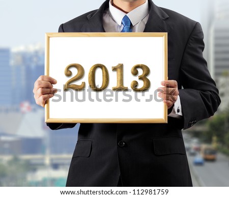 Business man holding white board Wood letter 2013