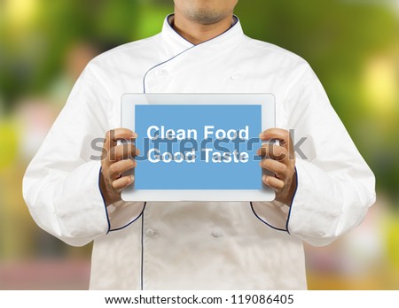 Chef showing a digital tablet with Text Clean Food Good Taste