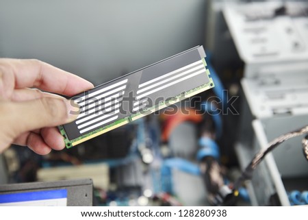 Hands holding PC RAM for installation