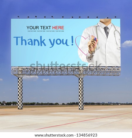 Doctor writing a pink heart with Thank you text on outdoor billboard