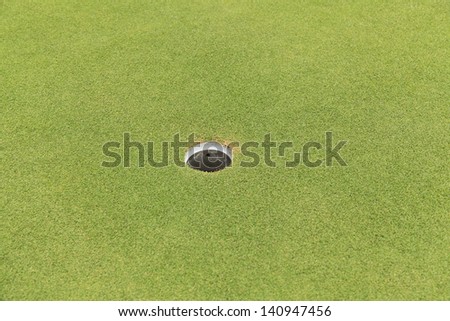 Golf hole on green grass