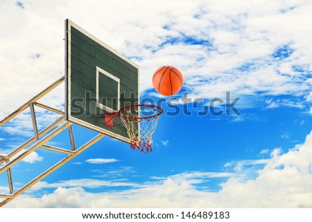 Basketball basket and ball on blue sky