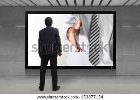 Business Man Gives A Handshake Out Of Tv Screen