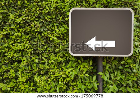 Blank Sign with arrow on green leaves wall
