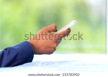 Close-up portrait of a relaxed man using the phone on the bed at home