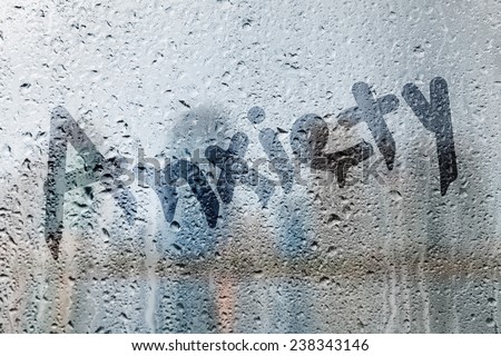 Rain on glass with anxiety text