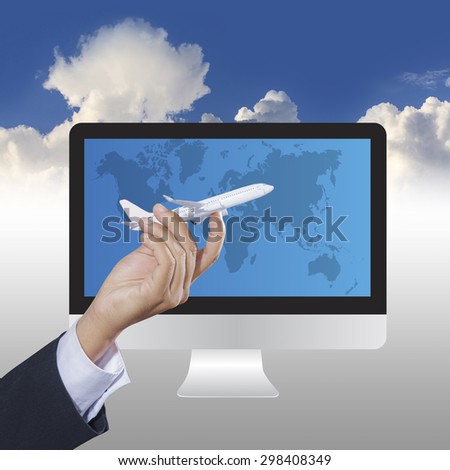 Airplane in hand with world map and computer on blue sky