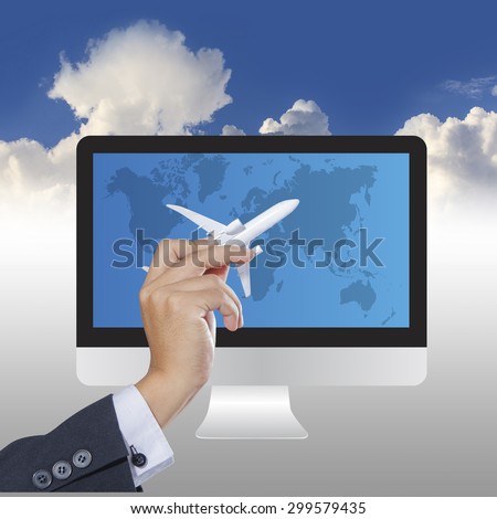 Airplane in hand with world map and computer on blue sky