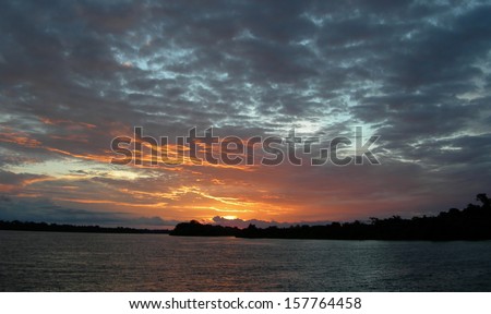 Fiery sunset and sky over the Rio Negro in the Amazon River basin, Brazil, South America