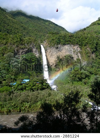 Waterfall in equatorial rainforest, with rainbow over fall, in Ecuador South America
