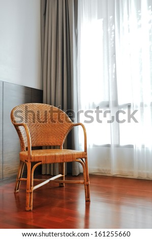 single wicker chair in living room with wood floor create a natural feel.