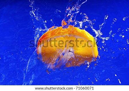 Orange falls into the blue water