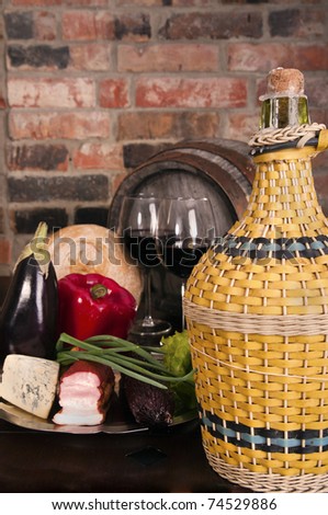 Still life with wine,vegetables, cheese and ham. Against the backdrop of a brick wall.