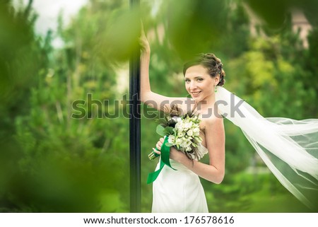 Bride in a flowing dress with a blurred background lawn.