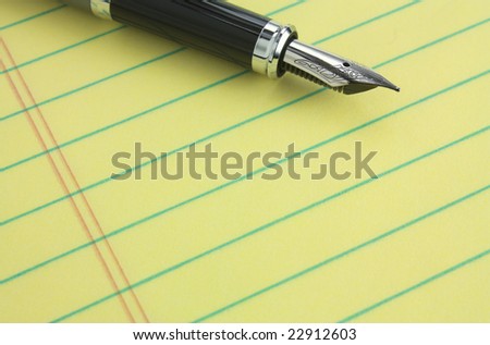 Fountain pen on yellow legal pad of paper - add your business message