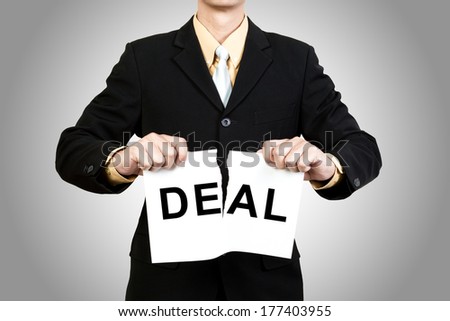 Businessman tear paper with word Deal on gray background