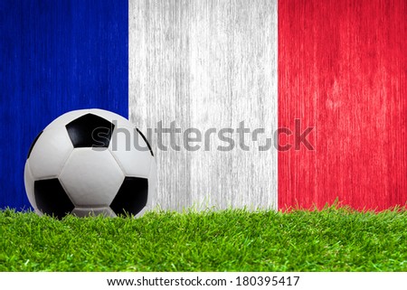 Soccer ball on grass with France flag background close up
