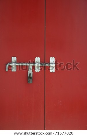 old iron lock with bolt on the red door found in a temple in Thailand