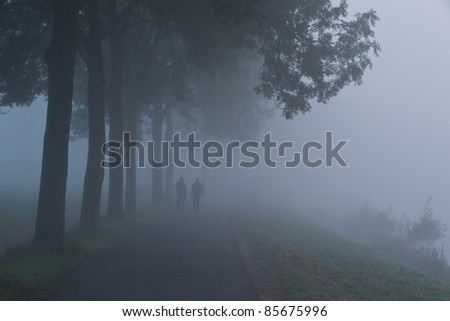 Two lonely people walking through the fog