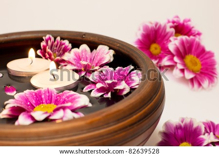 candles with flower in water on white
