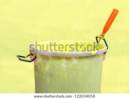 Paint-roller and Paint bucket with paint on a green background