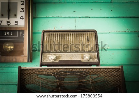 Retro Radio player and clock in room with green wood wall,