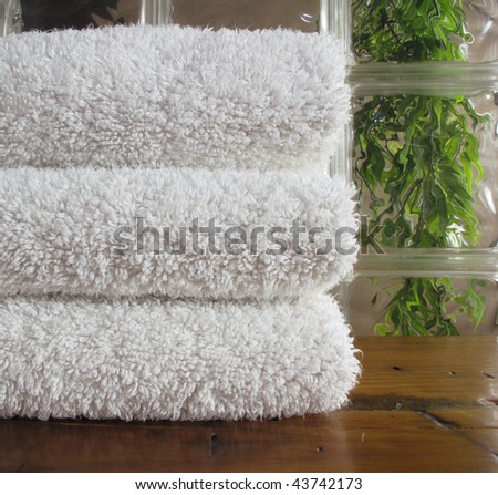Clean white bath towels framed by glass block