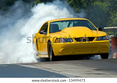 Vintage Stock  Auto Racing on Yellow Race Car  Takes Off  Down The Track During The Race Stock Photo