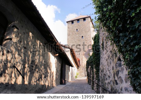 On the way to a castle courtyard in South Tyrol, Italy; old walls, light and shadow and a cloudless sky/A castle courtyard