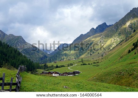 Landscape in the Stubai Valley in Tyrol, Austria, mountains, partial in clouds, alpine pastures, steep rocks, green meadows, cloudy sky/Landscape in the Stubai Valley