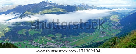 Panoramic view of the Stubai Valley in Tyrol, Austria; on the other side of the valley rise the Stubai Alps; a veil of clouds over the valley/ A veil of clouds over the valley