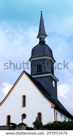 Village church in Saxony, Germany, a  steeple and slate roof, cloudy sky/Village church