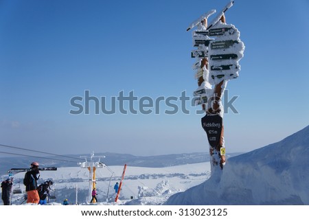 thickly snow-covered and frost-covered signposts on the Fichtelberg in the Ore Mountains in Saxony, Germany, overlooking the Bohemian part of the Erzgebirge in the Czech Republic/Signposts in winter