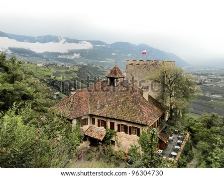 an old castle in South Tyrol; in the background  apple plantations, wine gardens and mountains An old castle