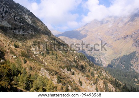Hiking in the Spronsertal in South Tyrol, Italy; barren landscape, steep slopes and blue sky with white clouds The Spronsertal in South Tyrol