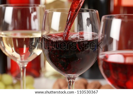 Red wine pouring into a wine glass. Selective focus on the red wine.