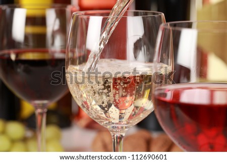 White wine pouring into a wine glass. Selective focus on the white wine.