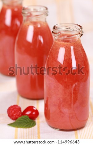 Freshly squeezed juice from red fruits in bottles