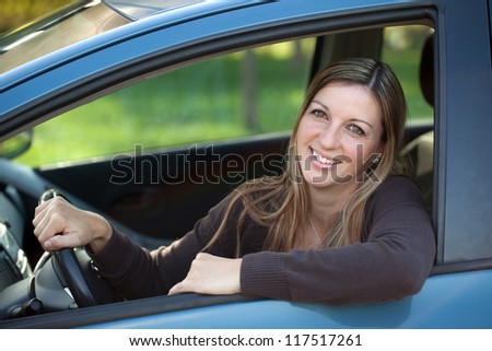 A relaxed driver leaning out of the window of the car