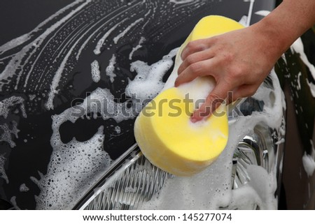 Washing a car with a sponge and a lot of foam