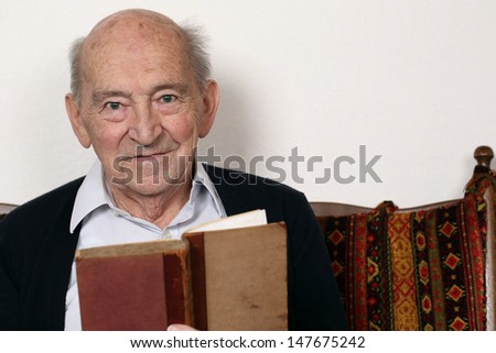 Portrait of an old grandpa reading a book