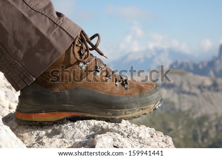 Hiking boots of a hiker on a rock in the mountains