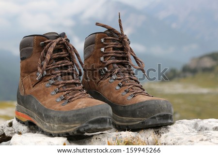 Hiking shoes of a hiker on a rock in the mountains