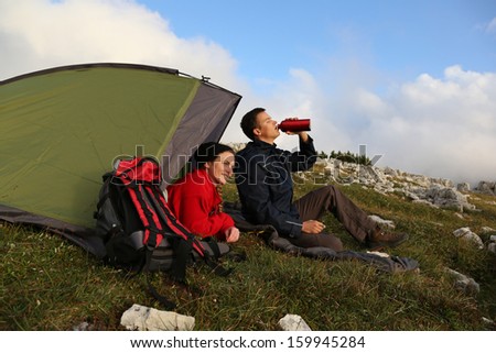 Young people camping in the mountains in the evening