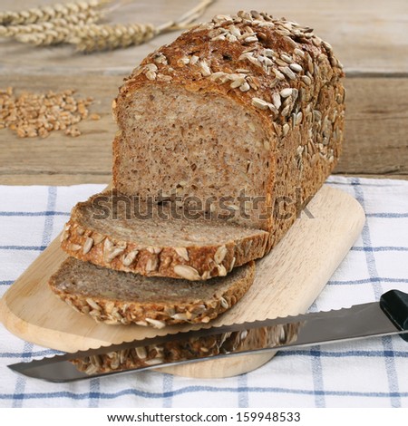 Whole wheat bread on a wooden board and a bread knife