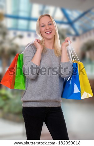 Smiling young woman shopping or buying in a store or mall