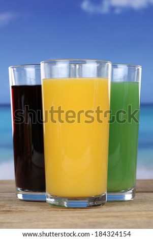 Colorful juices like orange and cherry juice in glasses