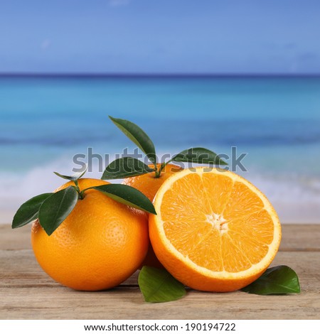 Fresh oranges fruits on the beach and sea with copyspace